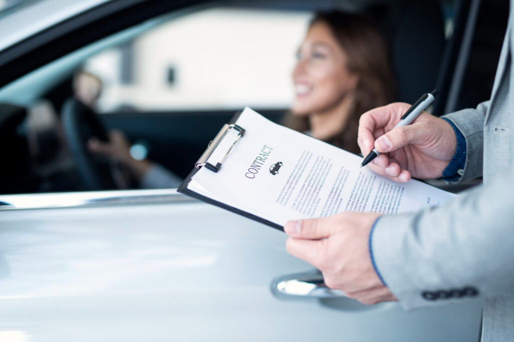 Hombre con contrato y mujer en auto