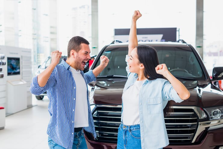 Pareja celebrando la compra de auto
